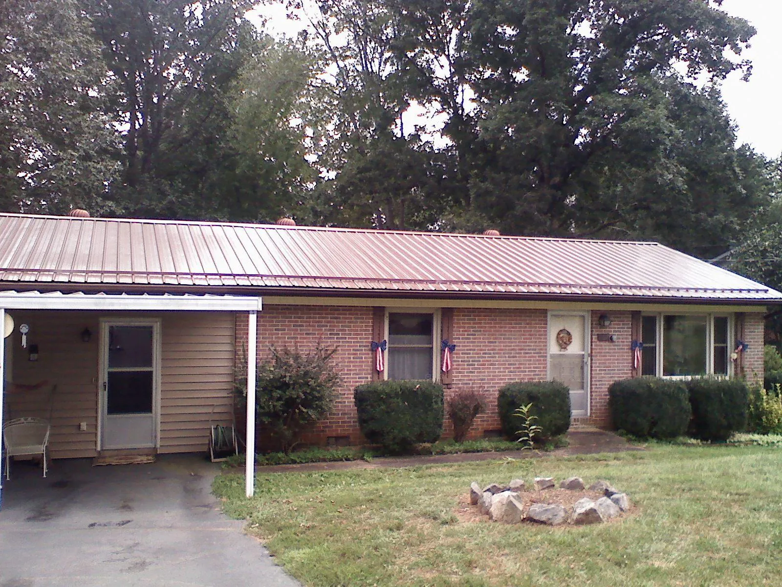 Bronze metal roof and carport on a brick ranch home — Roof Repair work by our crew in Mount Morris